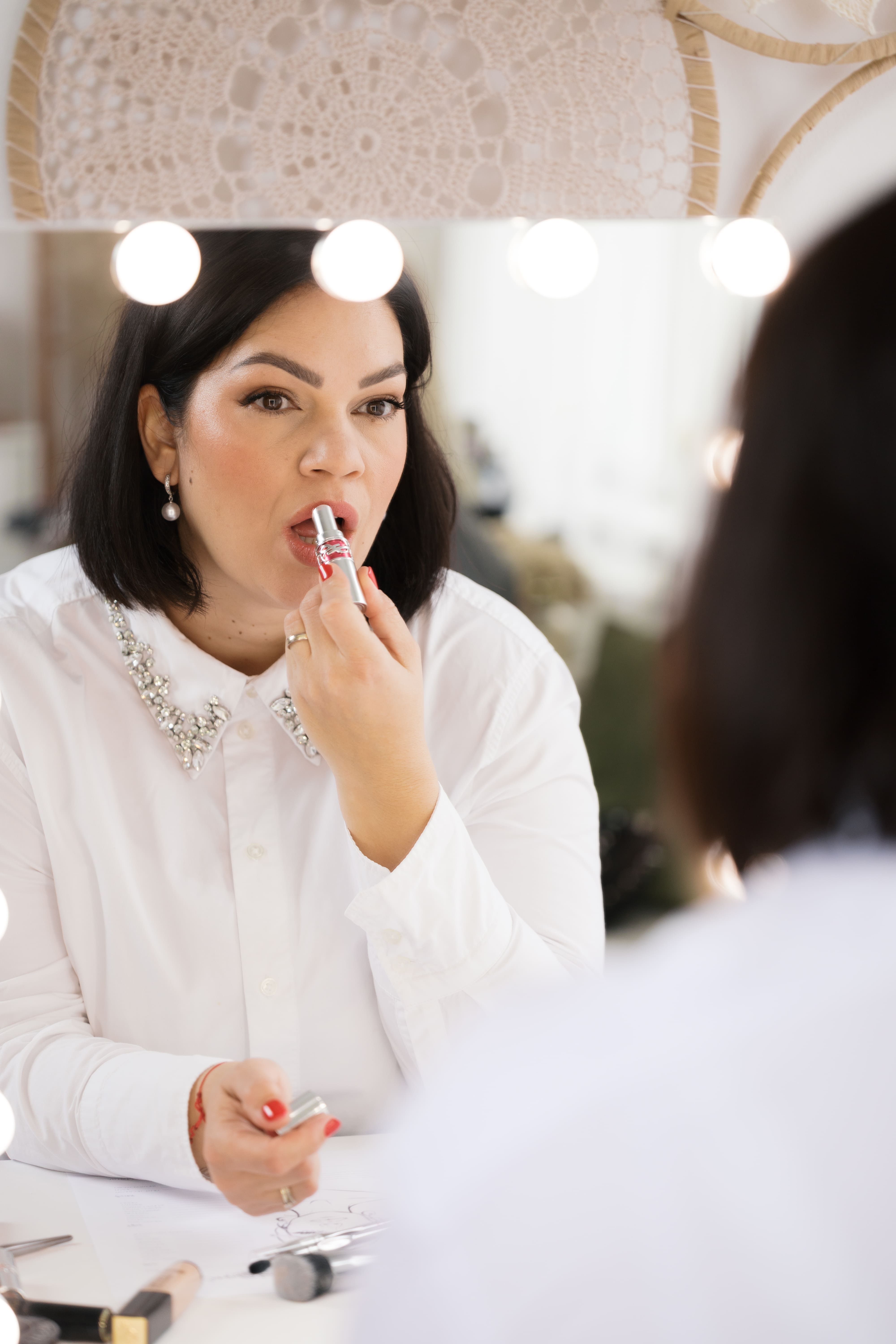 Szilvi, professionelle Make-up Artistin trägt Lippenstift auf
